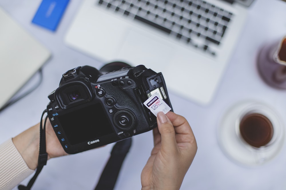 person holding black nikon dslr camera