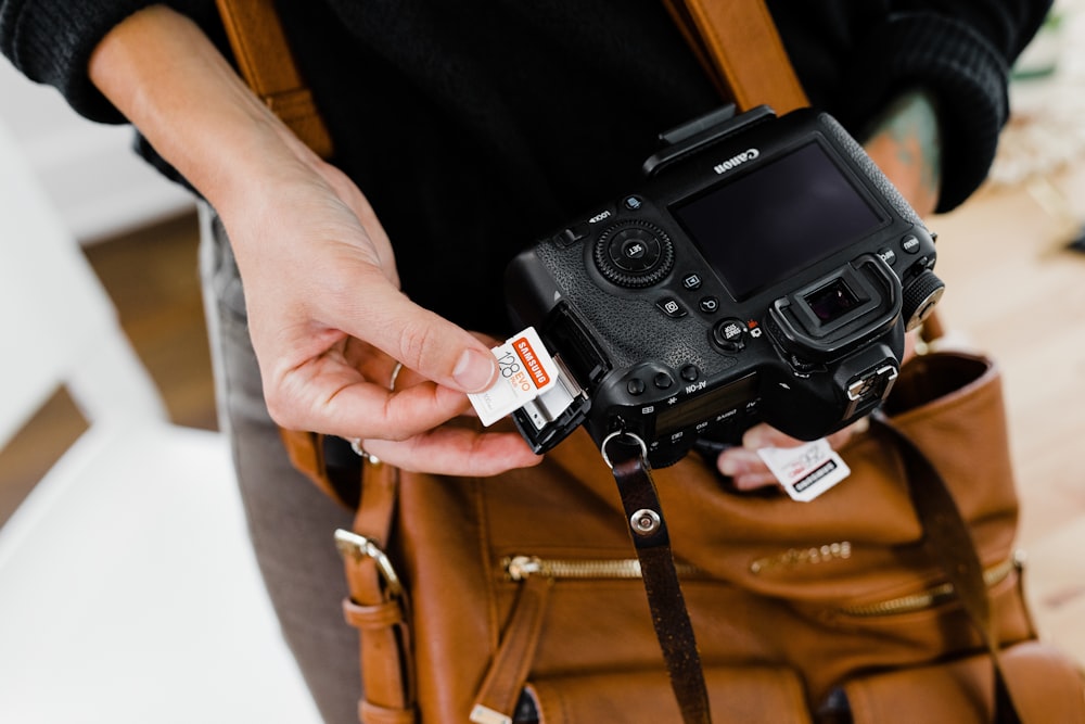 person holding black and silver dslr camera