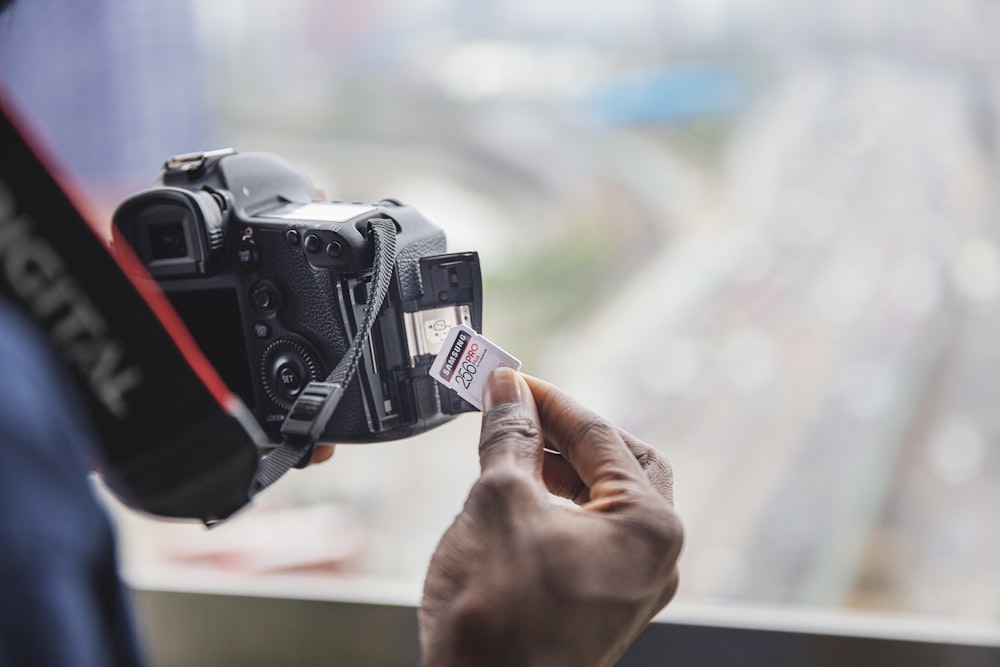 person holding black dslr camera