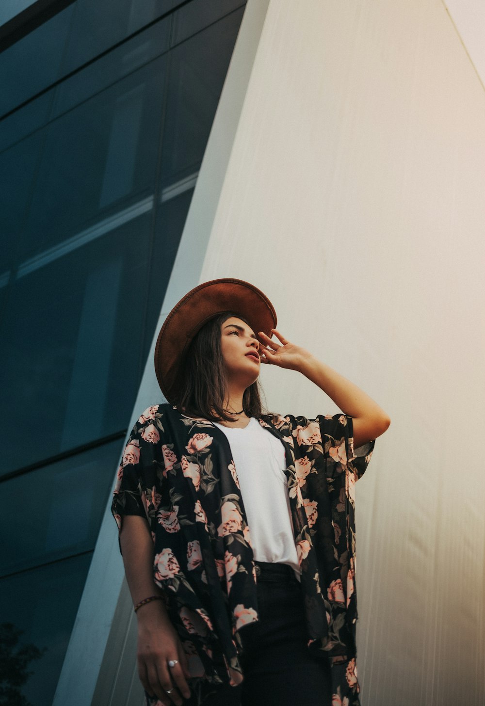 woman in white black and red floral shirt wearing brown hat