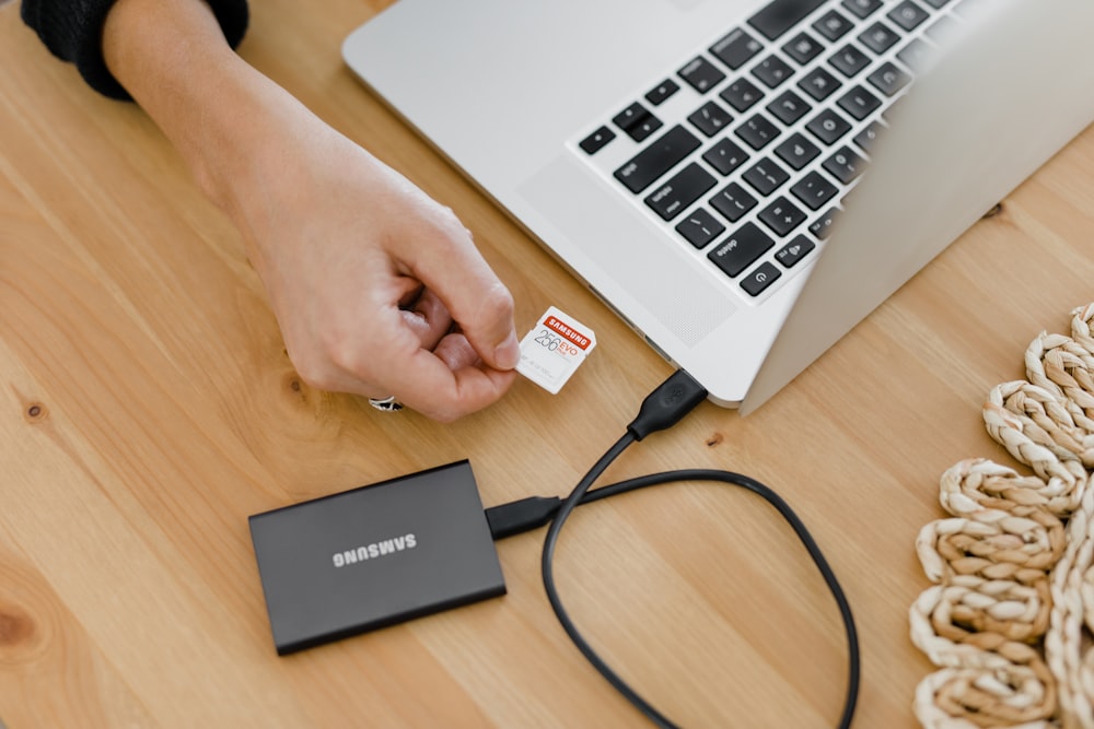 person holding black and silver laptop computer