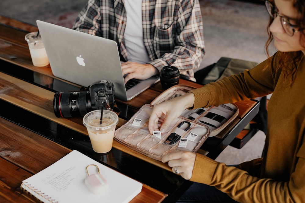 man in white and black plaid dress shirt using macbook