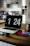 A cozy kitchen corner with neatly arranged gadgets and a glowing laptop showing a product review.