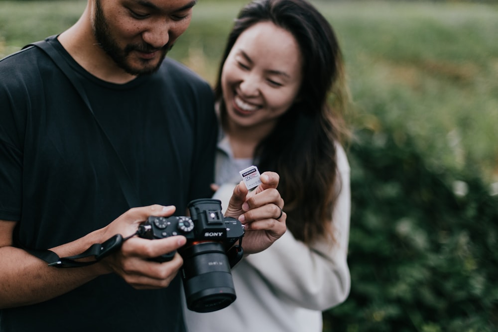 man in black crew neck shirt holding black dslr camera