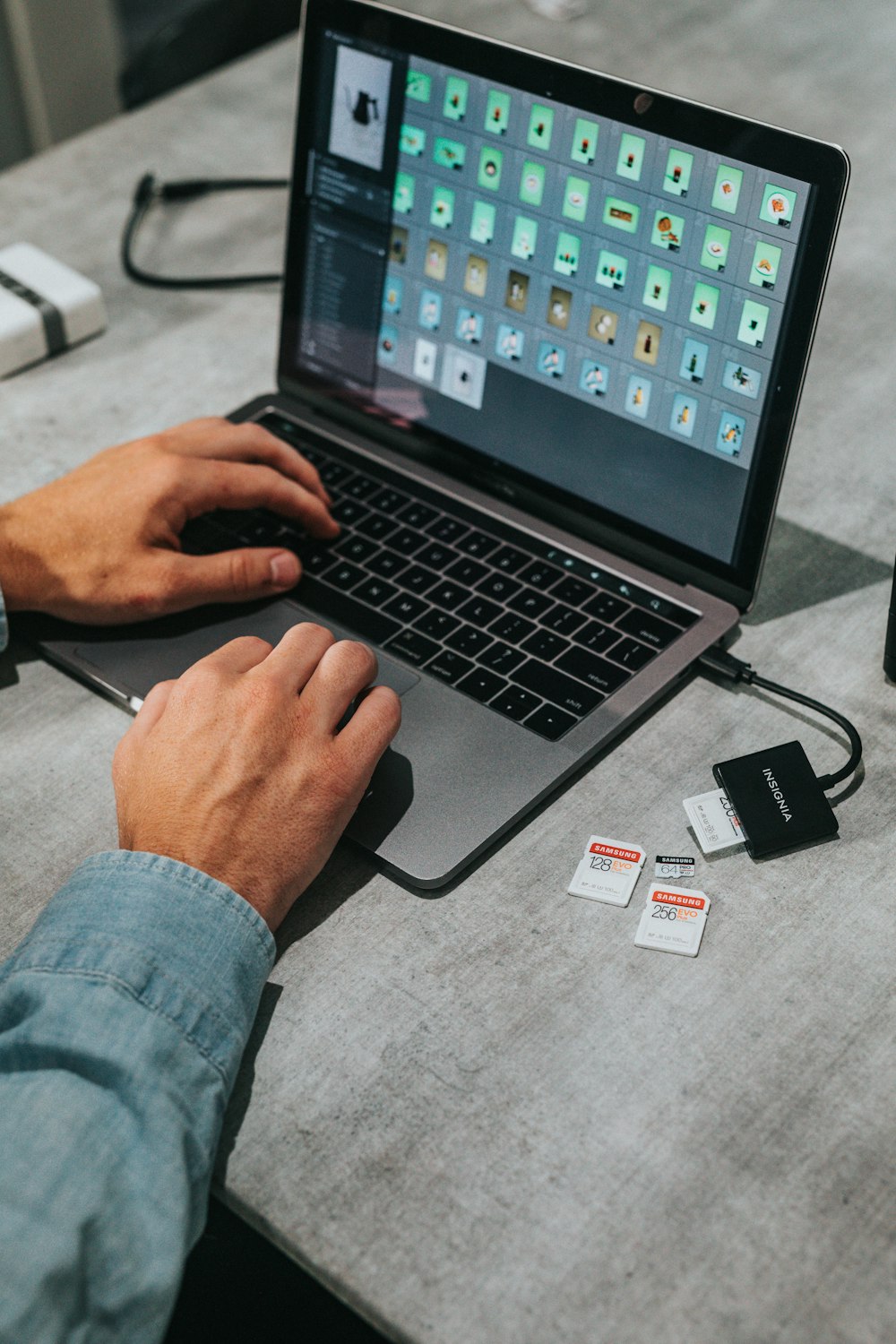 person in blue denim jeans using macbook pro