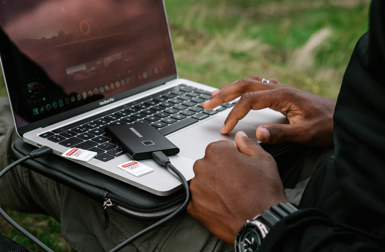 Photographer offloading footage from a camera to a portable SSD on a laptop