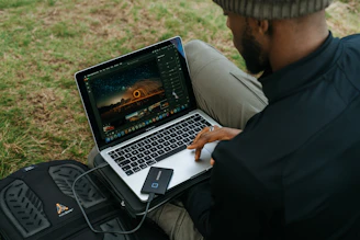 man in black jacket using macbook pro