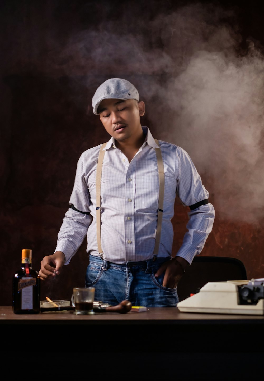 man in blue dress shirt and blue denim jeans holding beer mug