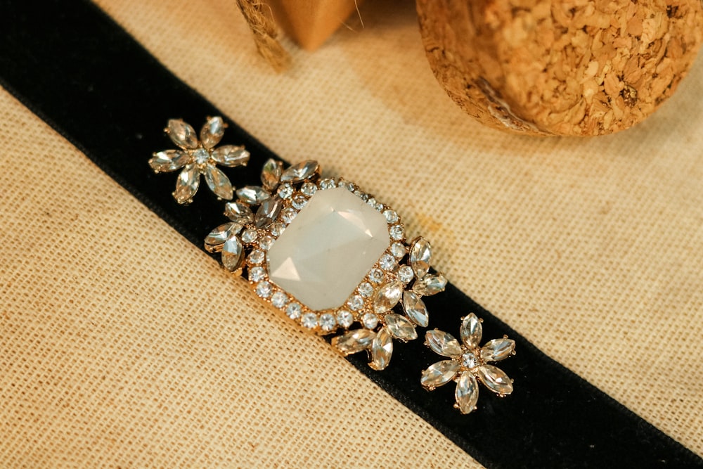 silver diamond studded ring on white textile