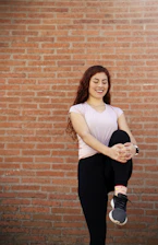 Woman doing pelvic floor exercises comfortably at home, smiling and relaxed.