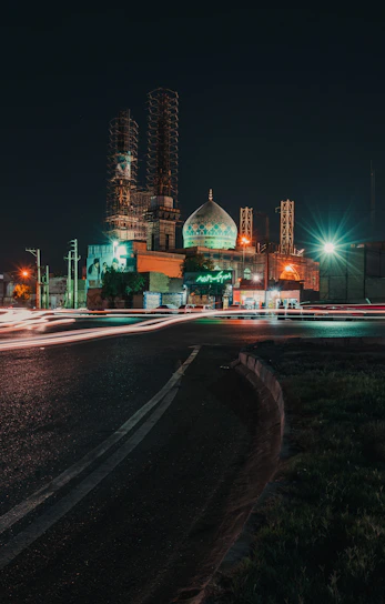 A vibrant emerald green mosque under construction with workers collaborating harmoniously.