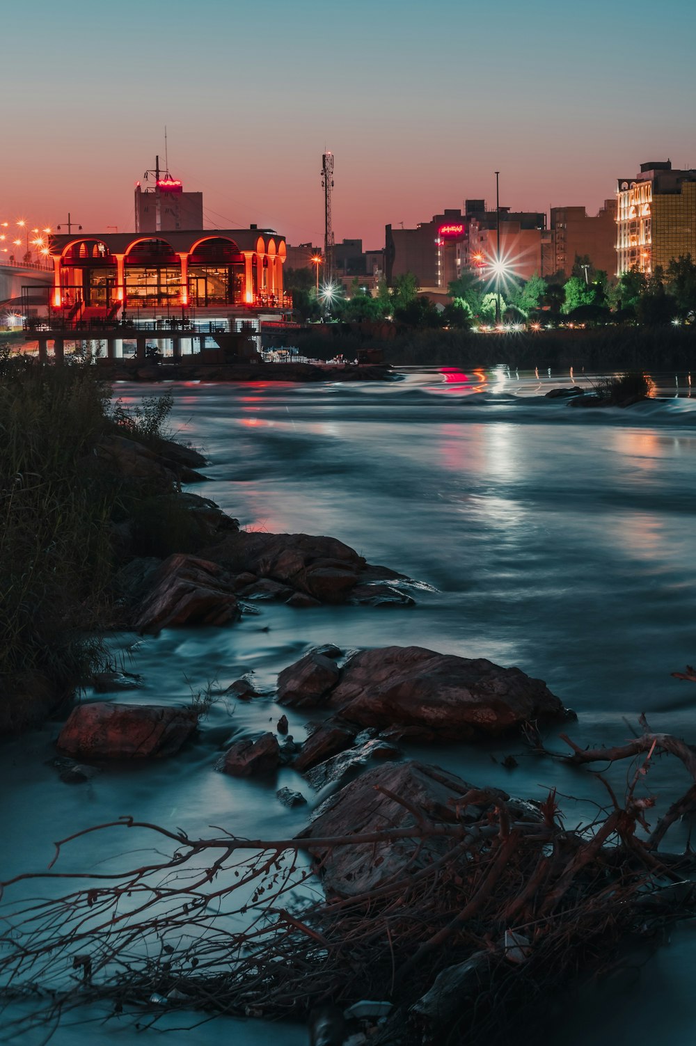 body of water near high rise buildings during night time