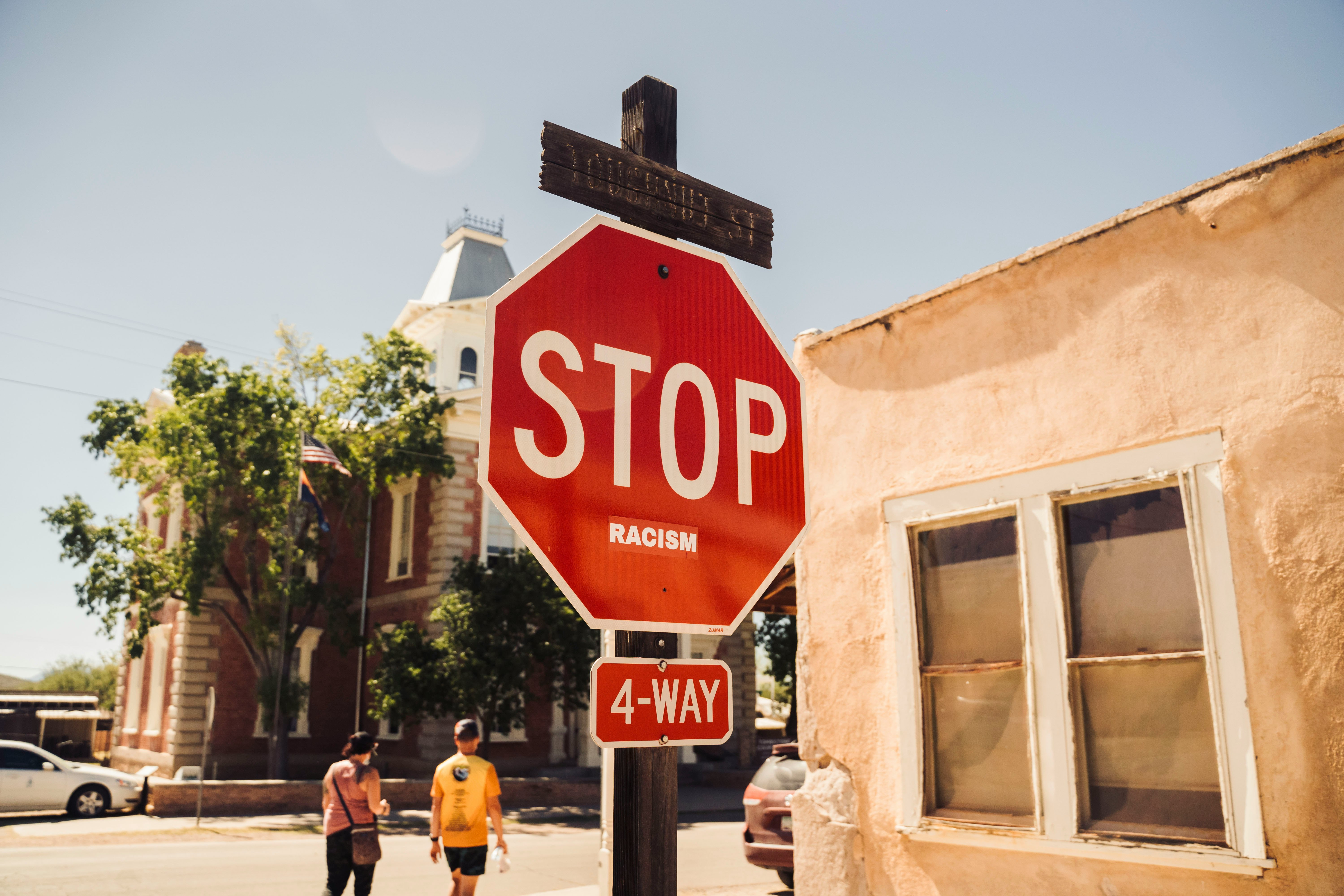 red stop sign near people walking on sidewalk during daytime