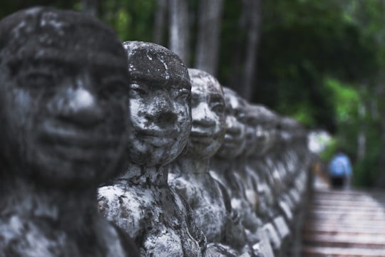 gray concrete statue near green trees during daytime in Kampong Thom Province Cambodia