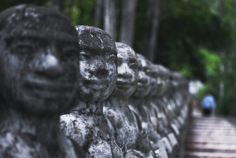 gray concrete statue near green trees during daytime