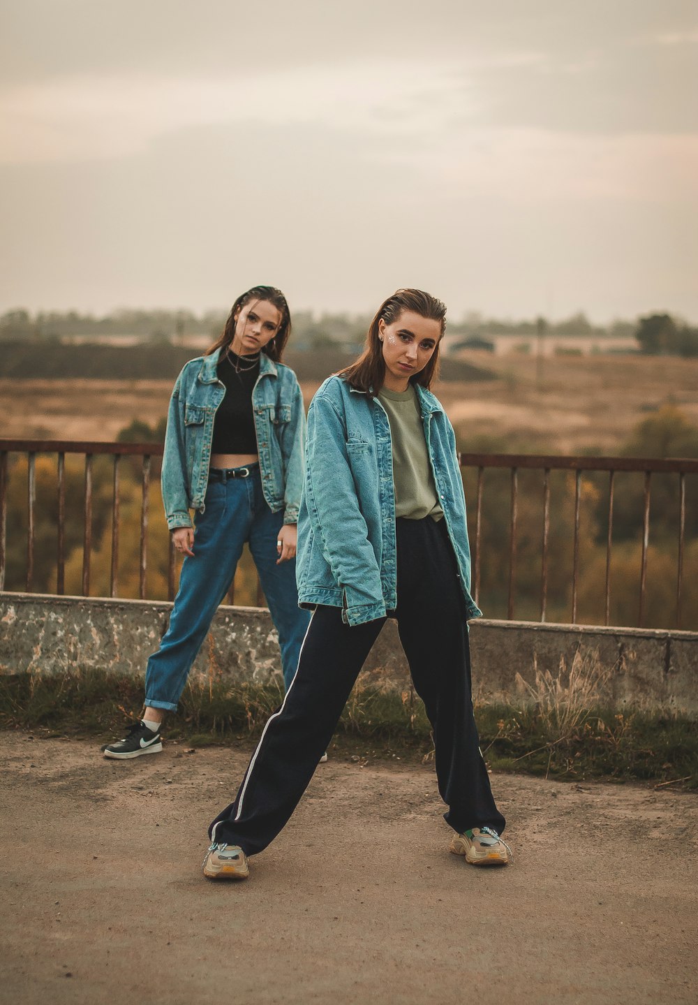 man in blue denim jacket standing beside woman in green jacket