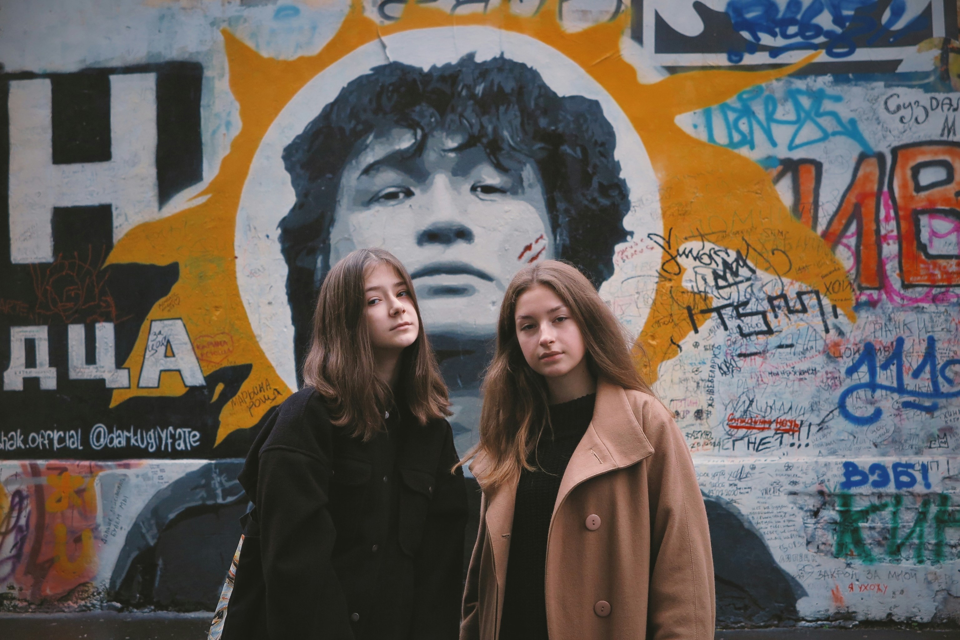 woman in black jacket standing beside woman in brown coat