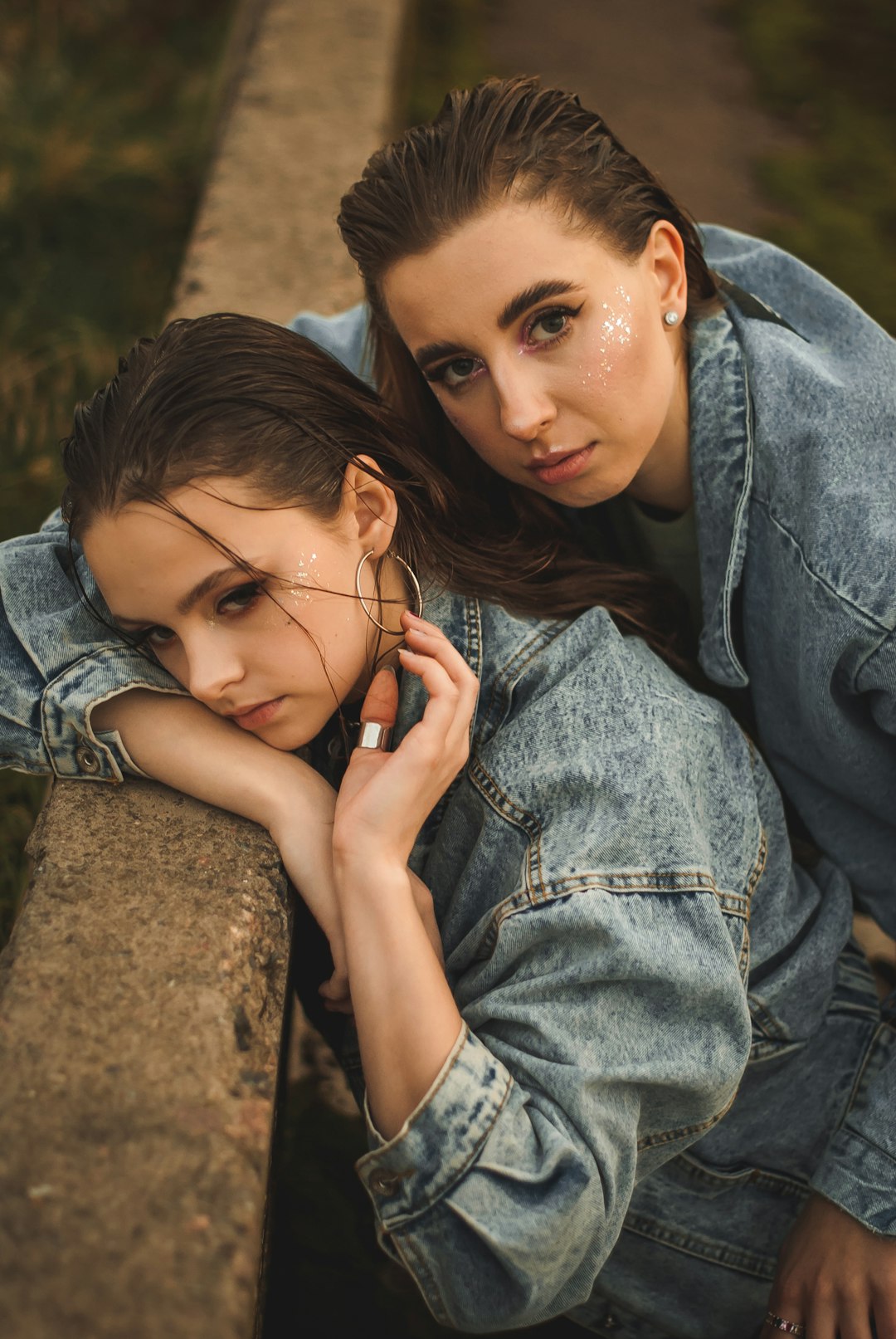 woman in blue denim jacket lying on brown rock