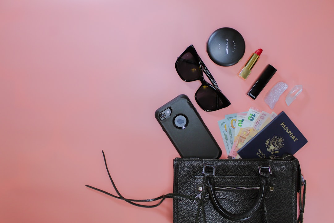 black sunglasses on black leather pouch, Flat lay featuring makeup and beauty items of a female traveler.