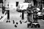 grayscale photo of woman in black jacket riding on black and gray stroller