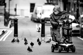 grayscale photo of woman in black jacket riding on black and gray stroller
