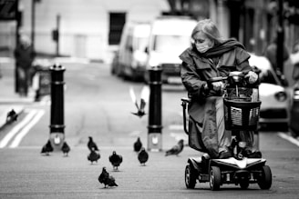 grayscale photo of woman in black jacket riding on black and gray stroller