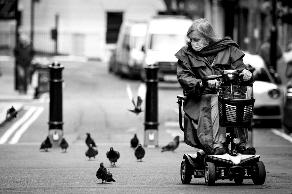 grayscale photo of woman in black jacket riding on black and gray stroller