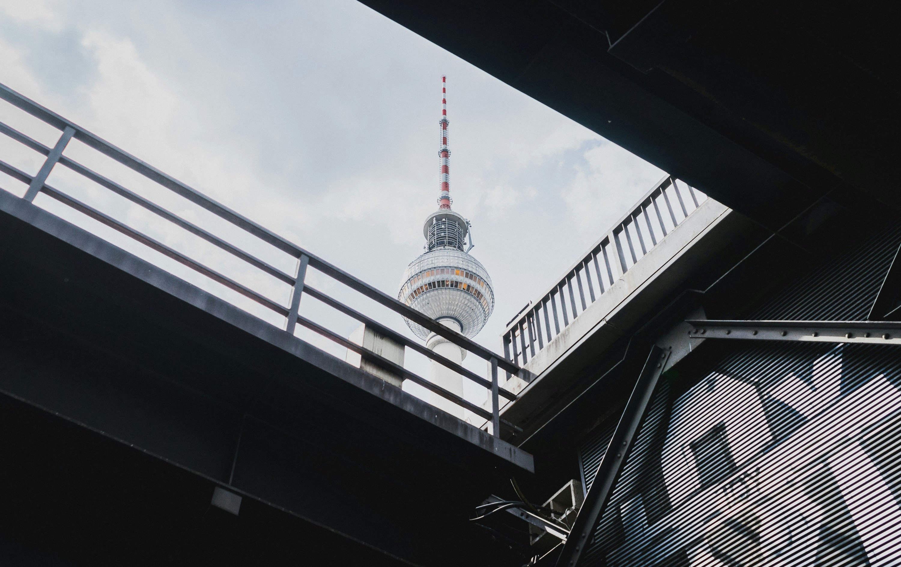 white and red tower under white clouds during daytime