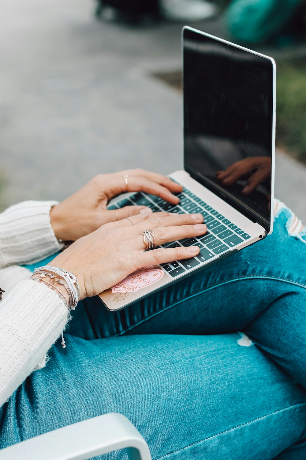 person in blue denim jeans using macbook pro