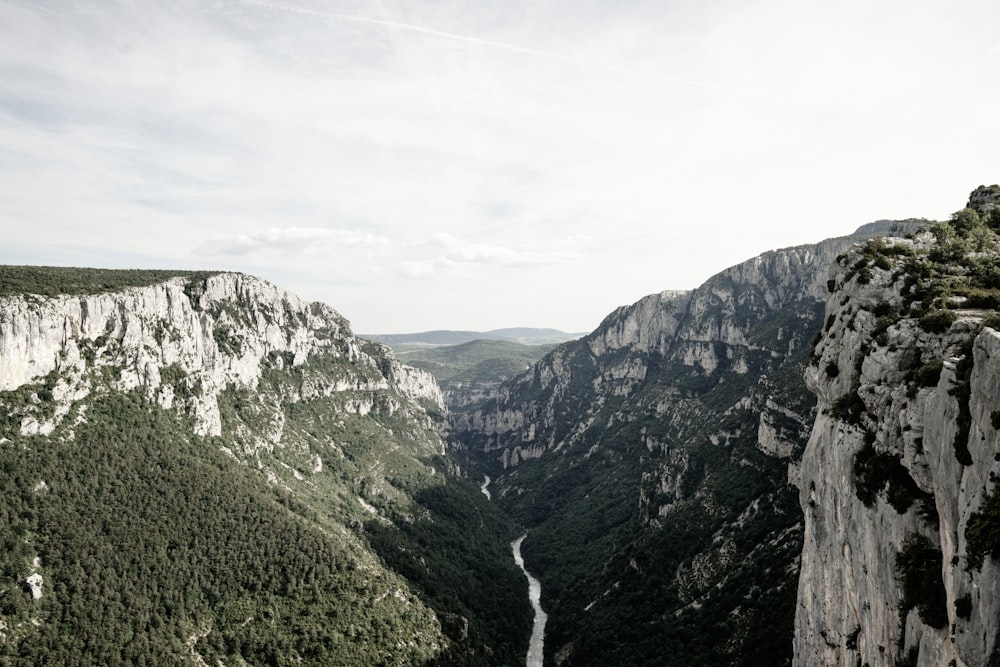 río entre montañas bajo el cielo blanco durante el día