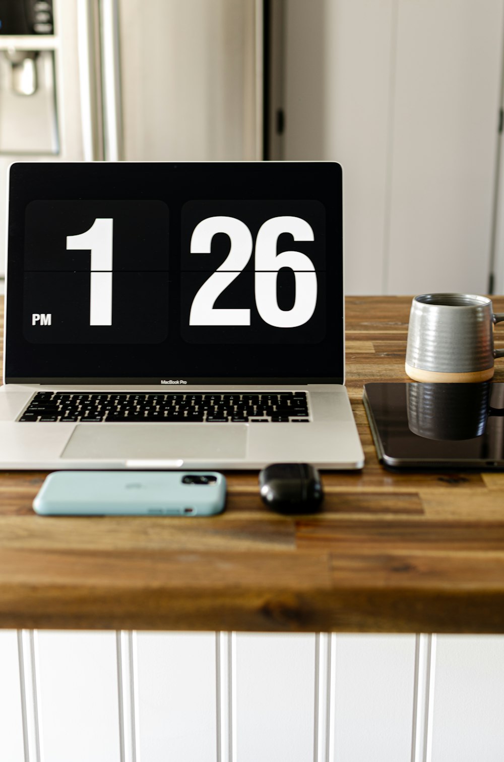 macbook pro beside black and silver portable speaker on brown wooden table