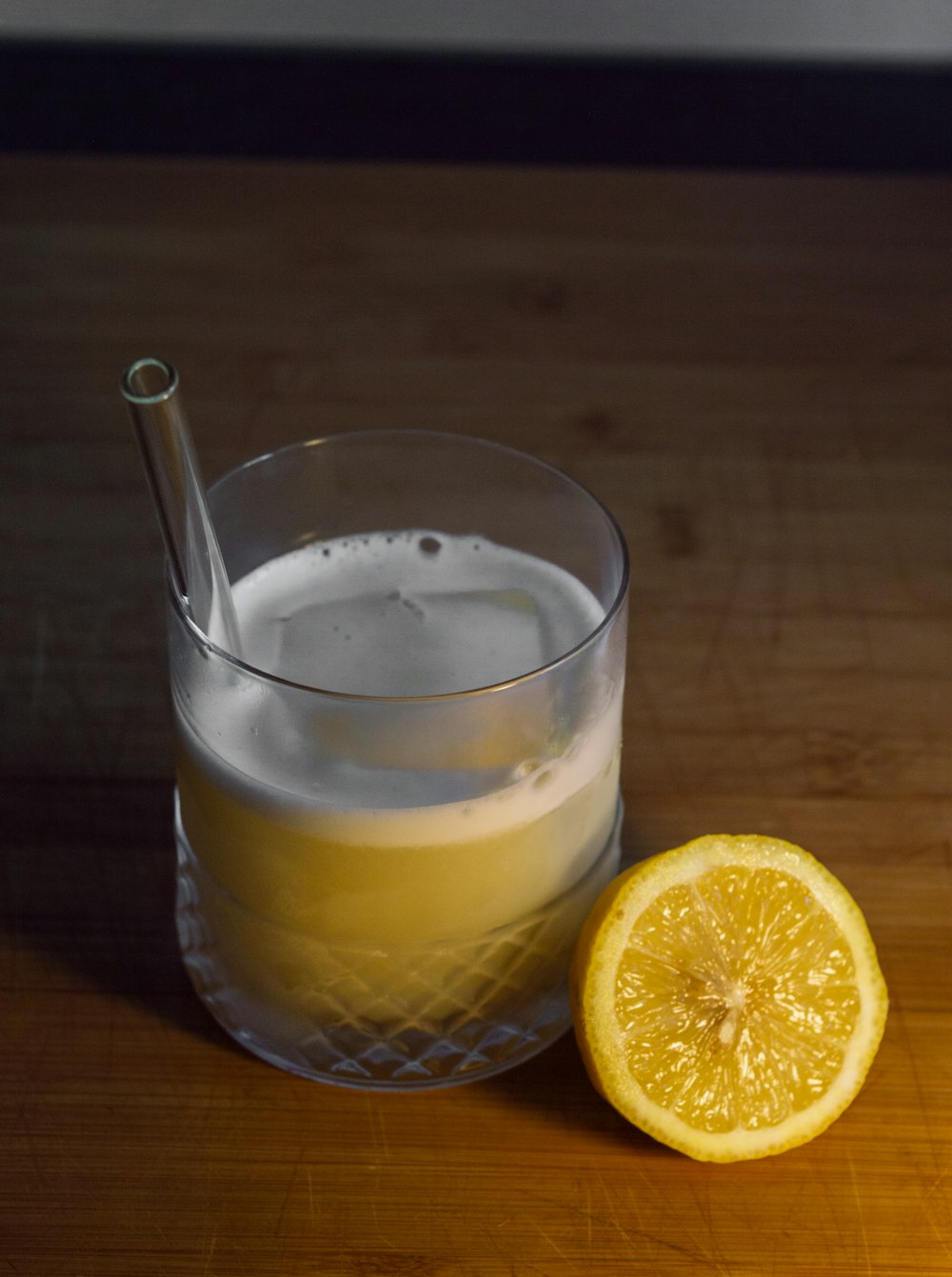 clear drinking glass with yellow liquid and sliced lemon