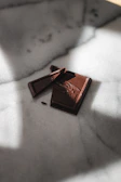 Artisan hand tempering rich dark chocolate on a marble slab.