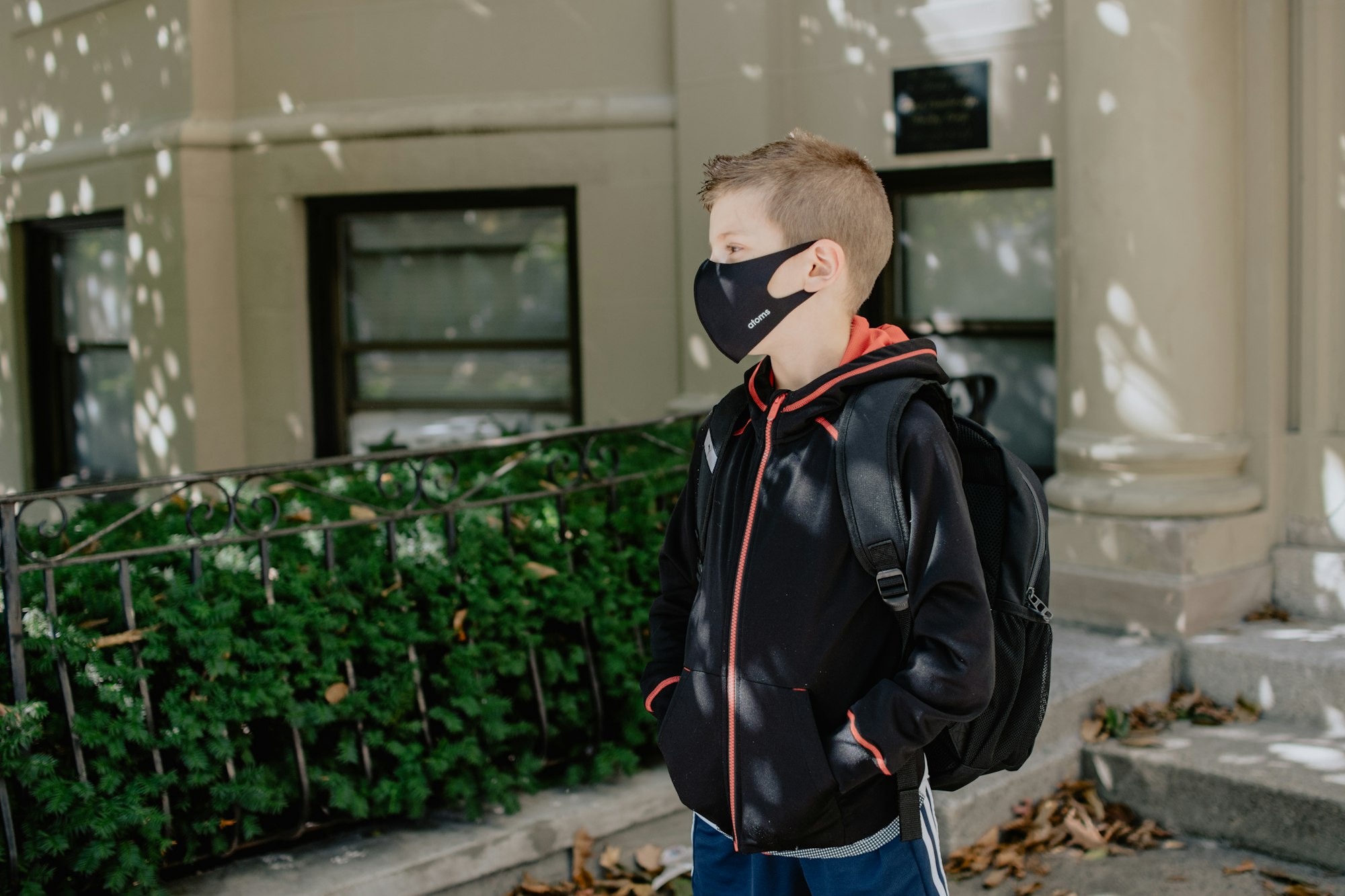 boy walking to school with a black mask on 