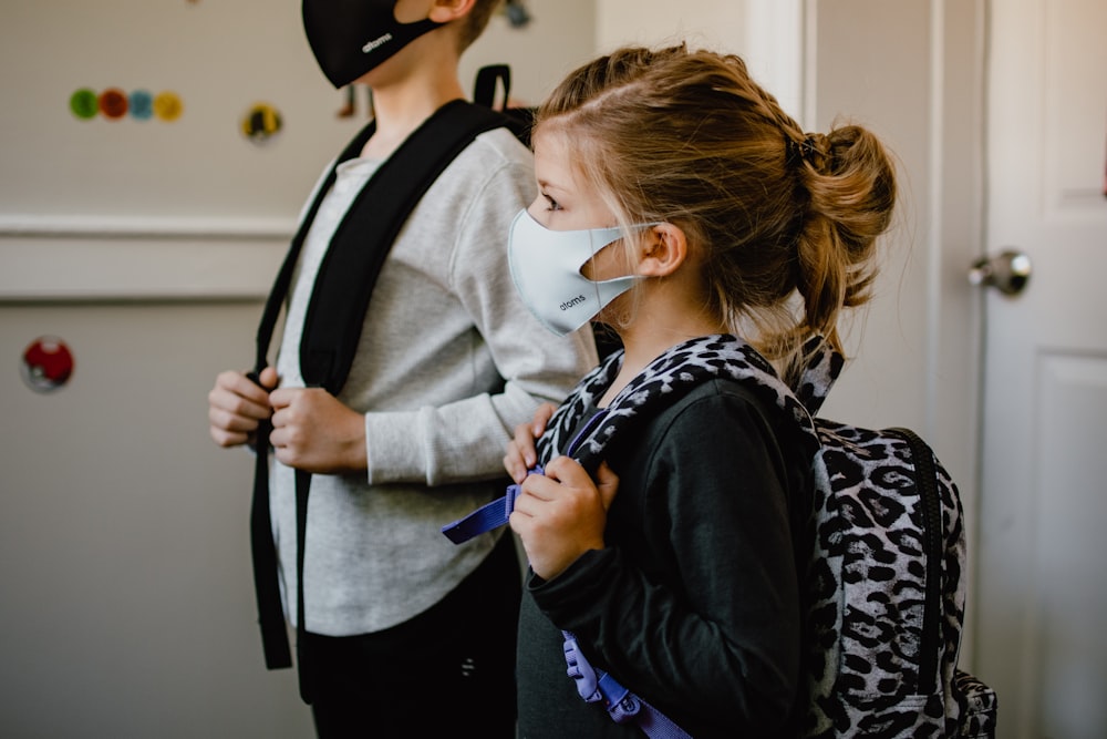 woman in black long sleeve shirt holding white face mask