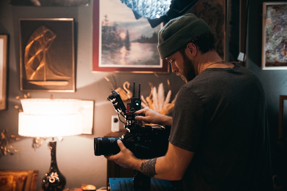 homem na camiseta preta segurando a câmera dslr preta