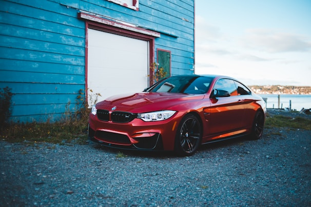 A sleek red sports car parked in a scenic location.