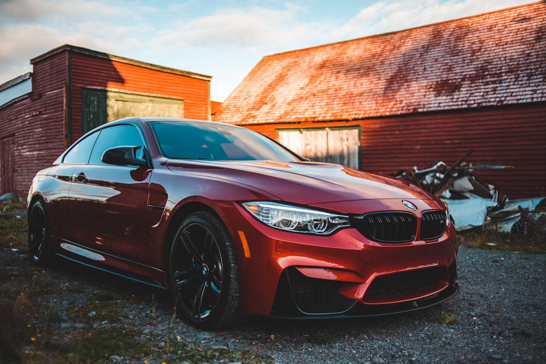 red bmw m 3 parked near brown wooden building during daytime