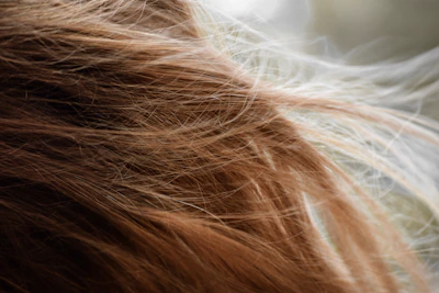 brown hair on white textile