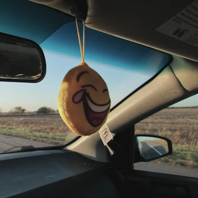 A colorful illustration of a happy family in a car, kids in the backseat smiling and listening to music with playful Ototo characters around.