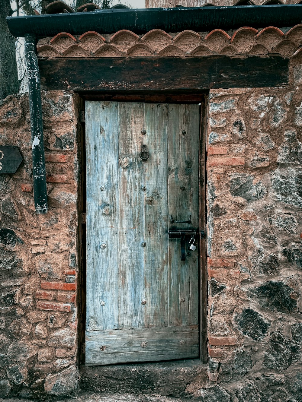 puerta de madera marrón sobre pared de ladrillo