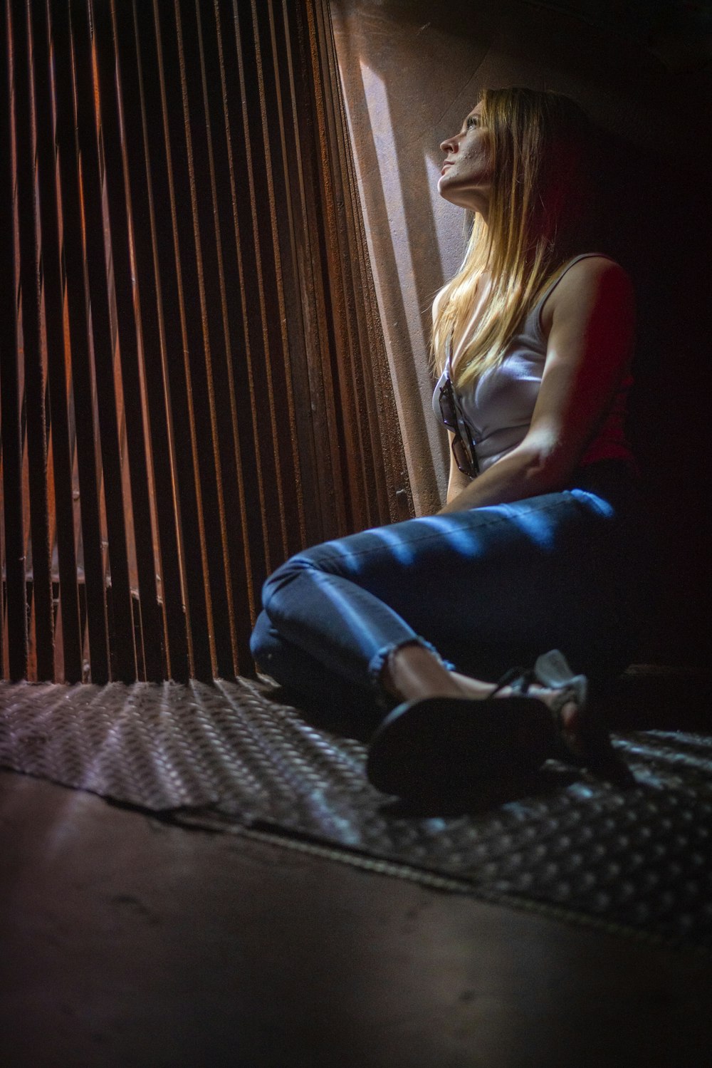 woman in blue denim jeans sitting on black and white stripe bed