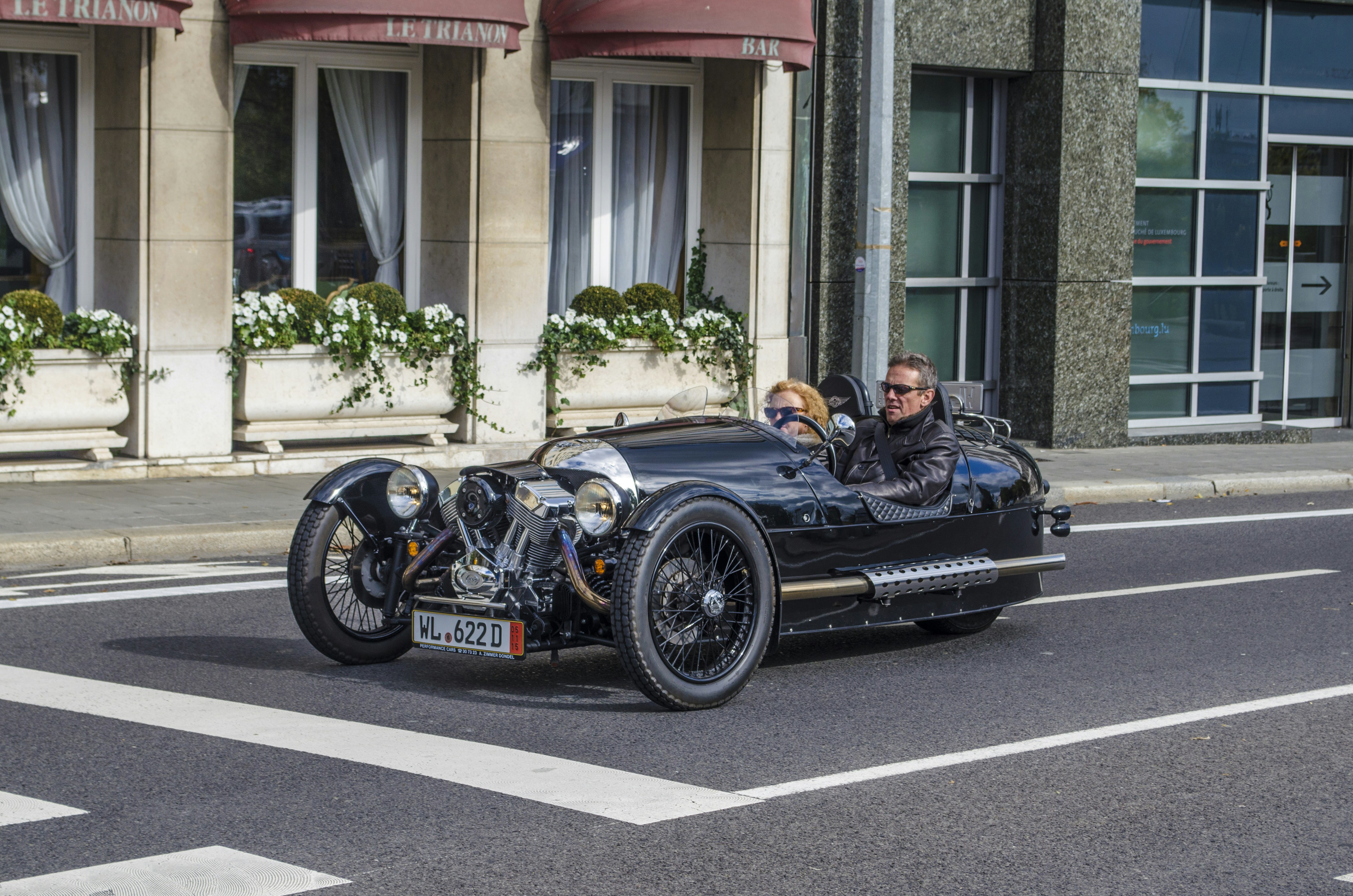 man in black jacket driving black convertible car