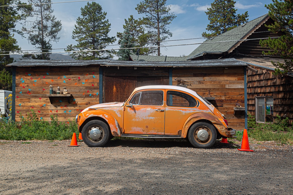 yellow volkswagen beetle parked beside brown wooden house during daytime