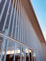 Exterior facade of a building featuring a newly painted surface and installed glass panels.