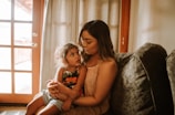 Parent and child sharing a moment in a bright room.