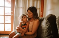 A smiling mother and child sharing a quiet moment in a small home, illuminated by soft natural light, symbolizing the impact of habby’s aid.