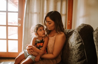 A warm and inviting scene of a mother reading a book to her child in a cozy living room.