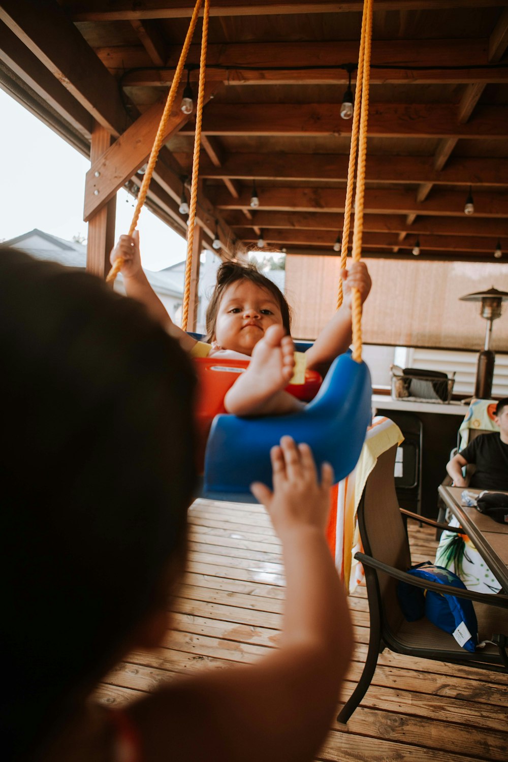 girl in blue shirt sitting on swing