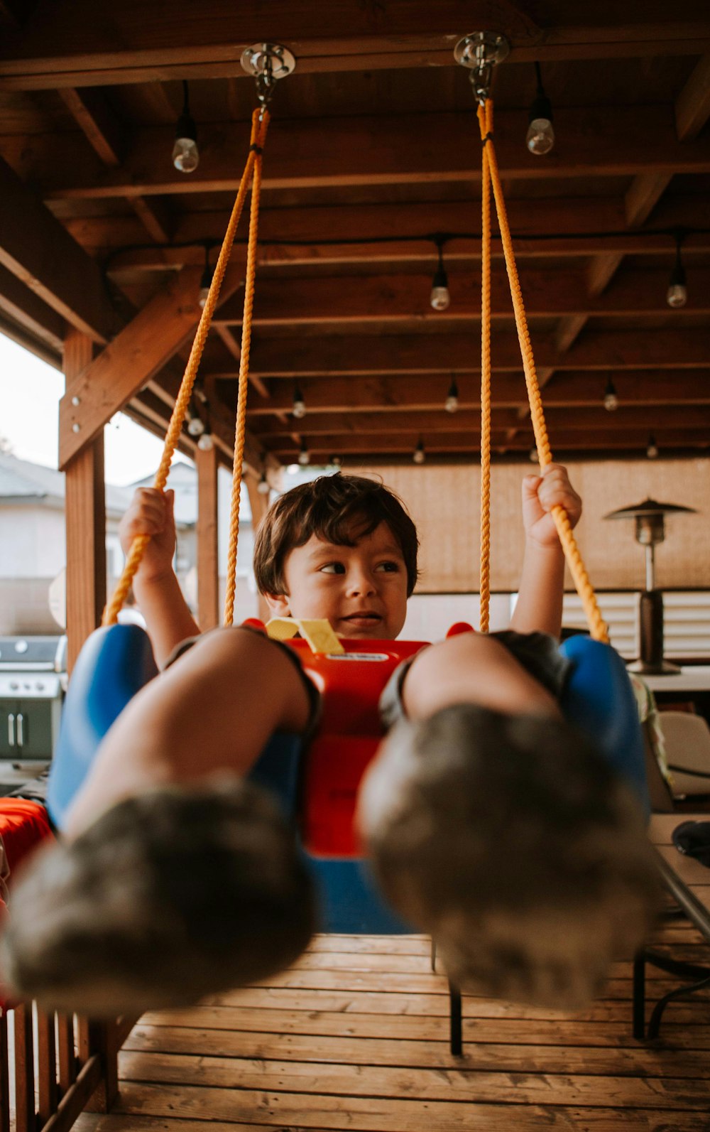 boy in red shirt sitting on swing